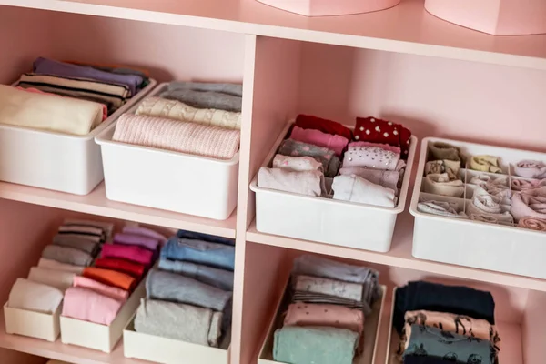 Closeup prateleiras rosa feminino armário infantil com roupas bem dobradas Marie Kondo armazenamento vertical — Fotografia de Stock