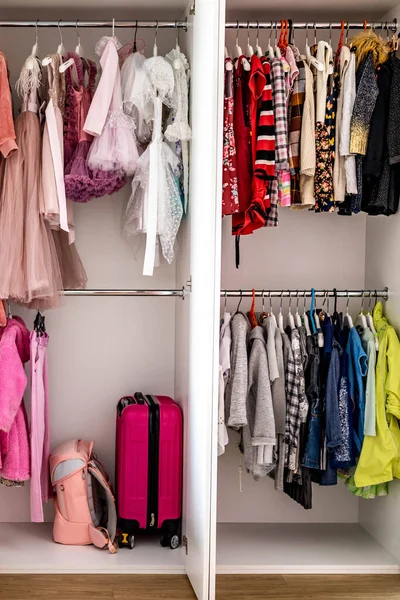 Жіночий дитячий гардероб висить на зручному вертикальному зберіганні Мінімалістський метод Марії Кондо — стокове фото