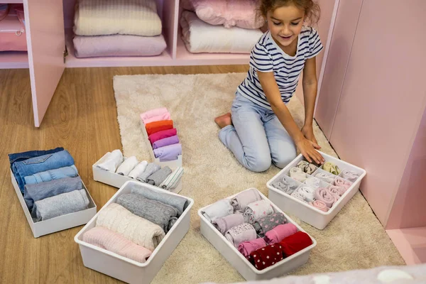 Menina feliz perfeitamente rolo dobrado roupa interior e meias em caixa de recipiente de plástico método Marie Kondo — Fotografia de Stock