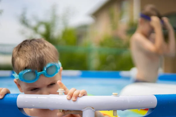 Havuzda yüzen parlak yüzme çemberleriyle küçük bir çocuk.. — Stok fotoğraf
