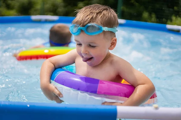 Havuzda yüzen parlak yüzme çemberleriyle küçük bir çocuk.. — Stok fotoğraf