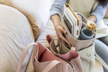 Kapalı kadın elleri modern konforlu depoyu hareket ettiriyor. Organizatörü deri çantaya dönüştürüyor.