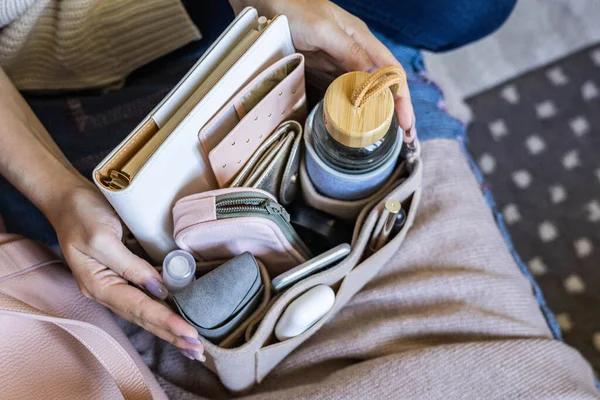 Closeup woman hands putting personal accessories into felt organizer. Concept storage organization — Stock Photo, Image