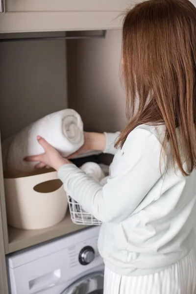 Sonriente ama de casa enrollado toalla de baño organizar el almacenamiento en el armario debajo del fregadero. Método Marie Kondos — Foto de Stock