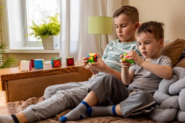 İki erkek kardeş Rubiks Küpü 'nü birleştirip mantıklı kararlar vermeyi düşünüyorlar.