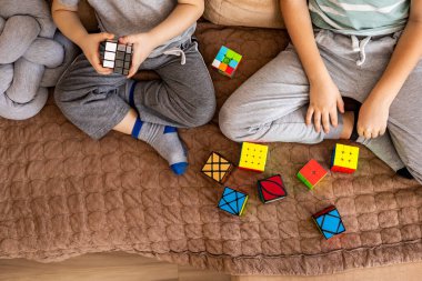 İki erkek kardeş Rubiks Küpü 'nü birleştirip mantıklı kararlar vermeyi düşünüyorlar.