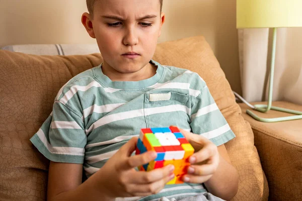 Retrato frunciendo el ceño adolescente macho lluvia de ideas montaje Rubiks cubo resolver decisión lógica mente — Foto de Stock