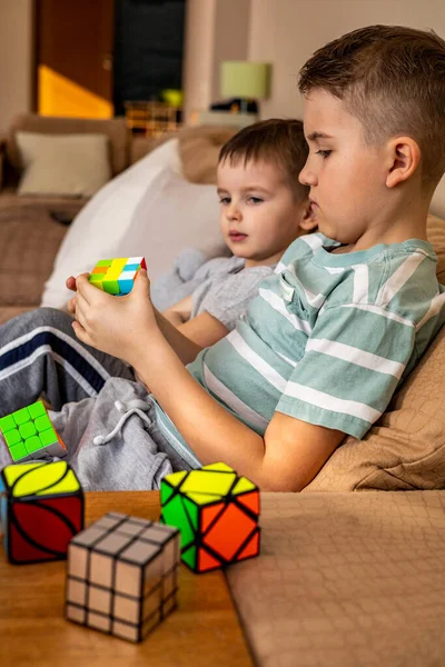 Twee mannelijke kinderen broers verzamelen Rubiks kubus denken oplossen logische beslissing Rechtenvrije Stockfoto's