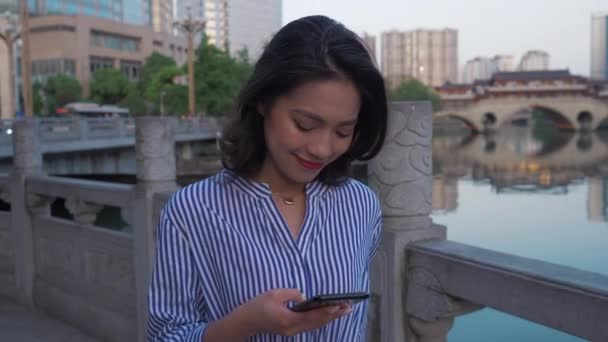 Jonge Aziatische vrouw met behulp van mobiele telefoon in Chengdu stad — Stockvideo