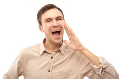 Beyaz stüdyo arka planında izole edilmiş yakışıklı beyaz erkek bağırıyor ve elleri ağızlarına dolanıyor. Heyecanlı haberler!