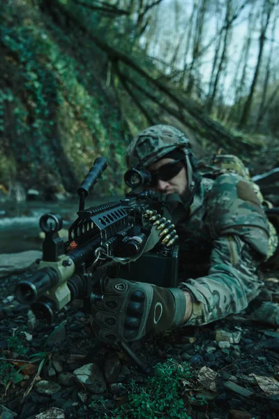 森の中の銃で犠牲者を目指してヘルメットのプロの機器でのエアソフトプレーヤーの肖像画 戦争中の武器を持つ兵士 — ストック写真