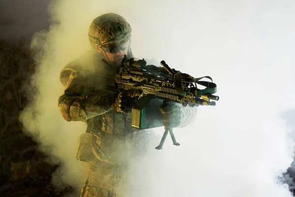 放棄された破壊された建物内の機関銃を持つプロの機器での空気ソフトプレーヤーの肖像画 煙と霧の中で戦争中の武器を持つ兵士 — ストック写真