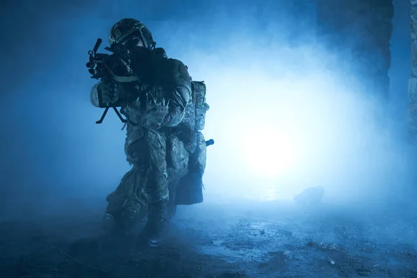 放棄された破壊された建物内の機関銃を持つプロの機器での空気ソフトプレーヤーの肖像画 煙と霧の中で戦争中の武器を持つ兵士 — ストック写真