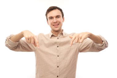 Üstü açık tişörtlü, beyaz saçlı yakışıklı esmer adam beyaz arka planda izole edilmiş ve fotokopi alanı olan boş bir yeri işaret ediyor. Ürünü gösteriyor, heyecan verici bir şey gösteriyor.