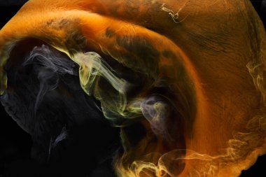 Siyah mürekkep arka planında turuncu duman, renkli sis, soyut girdap gibi dönen okyanus denizi, akrilik boya pigmenti su altında.