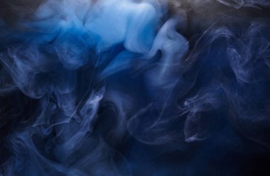 Siyah mürekkep arka planında mavi duman, renkli sis, soyut girdap gibi dönen okyanus denizi, akrilik boya pigmenti su altında.