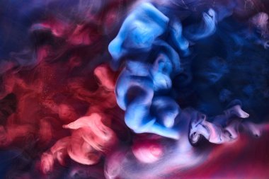 Siyah mürekkep arka planında mavi pembe duman, renkli sis, soyut girdap gibi dönen okyanus denizi, akrilik boya pigmenti su altında.