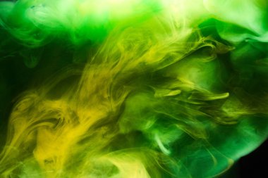 Siyah mürekkep arka planında yeşil duman, renkli sis, soyut girdaplı zümrüt okyanus denizi, su altında akrilik boya pigmenti