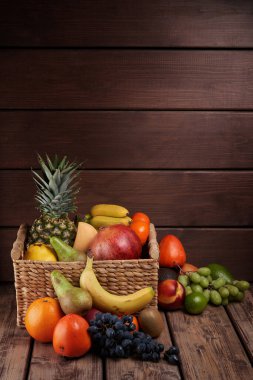 Tahta arka planda sepette taze renkli egzotik meyvelerin karışımı.