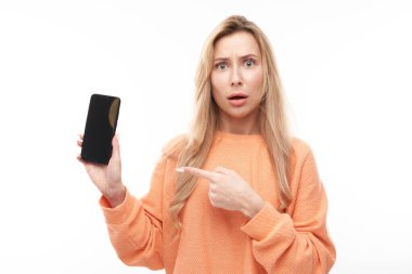 Güzel, heyecanlı sarışın kız akıllı telefon ekranında sıradan noktalarda ve beyaz stüdyo arka planında izole edilmiş gülücükler.