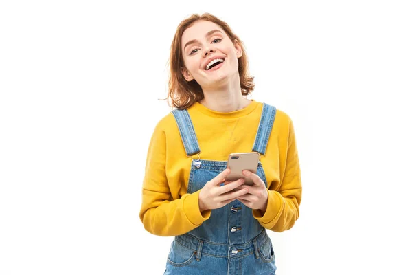 Menina Ruiva Sorridente Feliz Segurando Smartphone Mãos Roupas Amarelas Isoladas — Fotografia de Stock