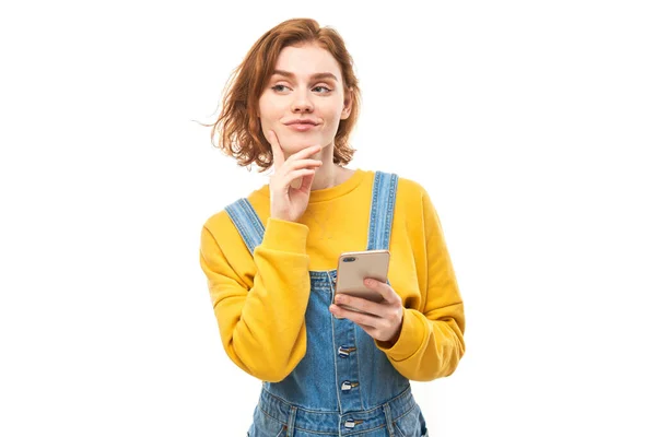 Menina Ruiva Sorridente Feliz Segurando Smartphone Mãos Roupas Amarelas Isoladas — Fotografia de Stock