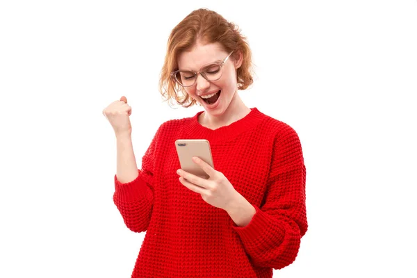Sorrindo Menina Ruiva Segurando Smartphone Roupas Vermelhas Com Óculos Isolados — Fotografia de Stock