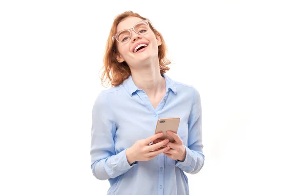 Menina Ruiva Sorridente Feliz Segurando Smartphone Mãos Óculos Camisa Negócios — Fotografia de Stock