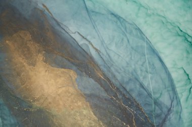 Alkol mürekkebi tekniğinde lüks zümrüt arka plan, yeşil altın sıvı boya, dağınık akrilik damlalar ve girdap lekeleri, basılı malzemeler.