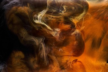 Siyah mürekkep arka planında turuncu duman, renkli sis, soyut girdap gibi dönen okyanus denizi, akrilik boya pigmenti su altında.