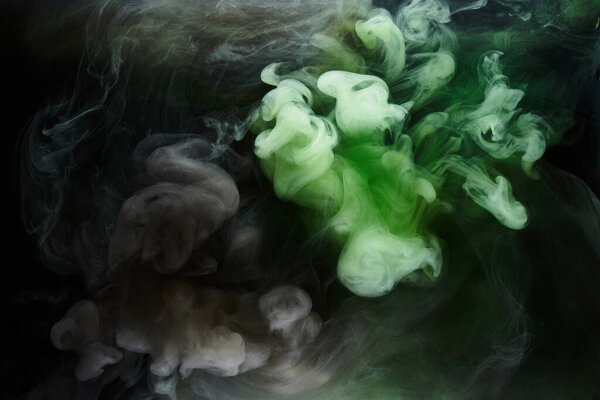 Green smoke on black ink background, colorful fog, abstract swirling emerald ocean sea, acrylic paint pigment underwater
