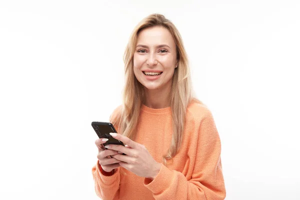 Menina Loira Bonita Olhares Casuais Para Tela Smartphone Sorrisos Isolados — Fotografia de Stock