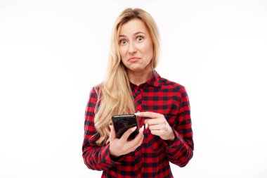 Güzel, heyecanlı sarışın kız akıllı telefon ekranında sıradan noktalarda ve beyaz stüdyo arka planında izole edilmiş gülücükler.