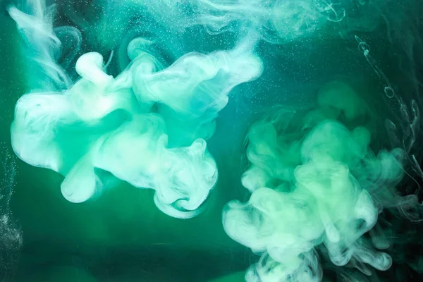 Siyah mürekkep arka planında yeşil duman, renkli sis, soyut girdaplı zümrüt okyanus denizi, su altında akrilik boya pigmenti