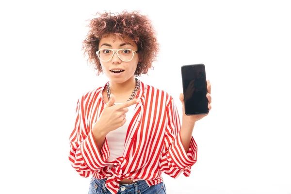 Feliz Chocado Encaracolado Caucasiano Menina Aponta Dedo Tela Branco Smartphone — Fotografia de Stock