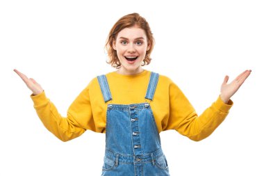 Şok olmuş, kızıl saçlı kız şaşırmış görünüyor. Ağzı açık, elleri beyaz stüdyo arka planına yayılmış.