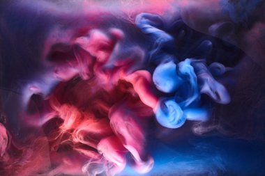 Siyah mürekkep arka planında mavi pembe duman, renkli sis, soyut girdap gibi dönen okyanus denizi, akrilik boya pigmenti su altında.
