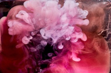 Siyah mürekkep arka planında pembe duman, renkli sis, soyut girdap dokunuşu okyanus denizi, akrilik boya pigmenti su altında