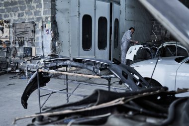 Araba tamircisi arabayı tamir ediyor.