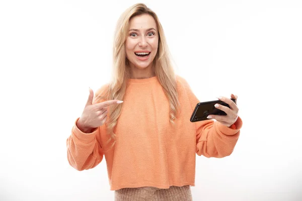 Vacker Upphetsad Blond Flicka Casual Punkter Smartphone Skärmen Och Leenden — Stockfoto