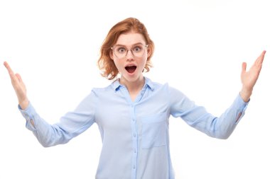 Şok olmuş yüzü kırmızı saçlı iş gömleği giyen kız ağzı açık beyaz stüdyo arka planına uzanan elleri görünce şaşırmış görünüyor.