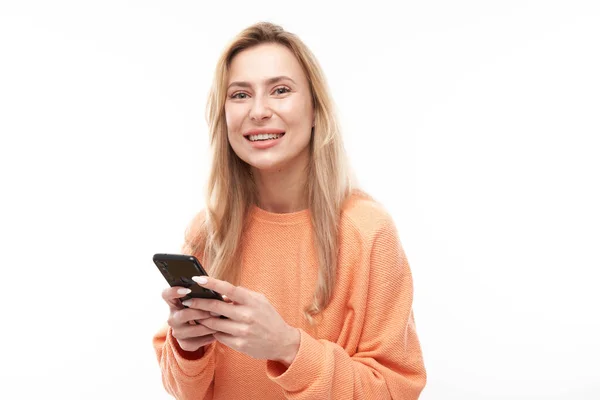 Menina Loira Bonita Olhares Casuais Para Tela Smartphone Sorrisos Isolados — Fotografia de Stock