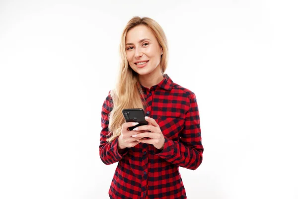 Vacker Blond Flicka Casual Tittar Smartphone Skärmen Och Ler Isolerad — Stockfoto
