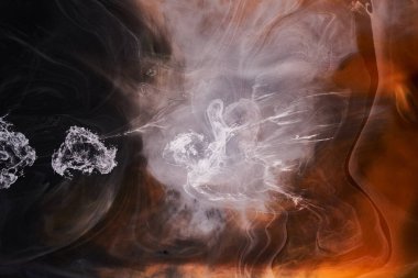 Siyah arkaplanda turuncu beyaz duman, renkli sis, soyut girdap dokunuşu okyanus denizi, akrilik boya pigmenti su altında