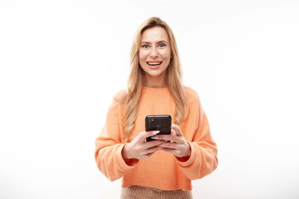 Vacker Blond Flicka Casual Tittar Smartphone Skärmen Och Ler Isolerad — Stockfoto