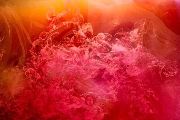 Turuncu pembe duman arka planı, renkli sis, soyut girdaplı mürekkep denizi, akrilik boya pigmenti su altında.