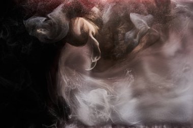 Siyah beyaz mürekkep arkaplan, renkli sis, soyut girdap gibi dönen okyanus, suyun altında akrilik boya pigmenti, koyu duman.