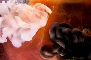 Siyah arkaplanda turuncu beyaz duman, renkli sis, soyut girdap dokunuşu okyanus denizi, akrilik boya pigmenti su altında