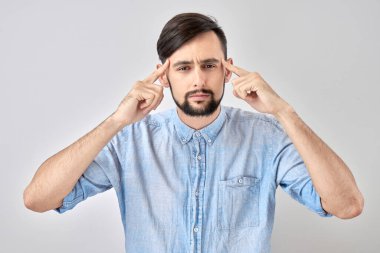 Uyanık, esmer bir adam kafasında şüphe uyandırıyor, kararlarını mavi stüdyonun arka planında yalnız bırakıyor.