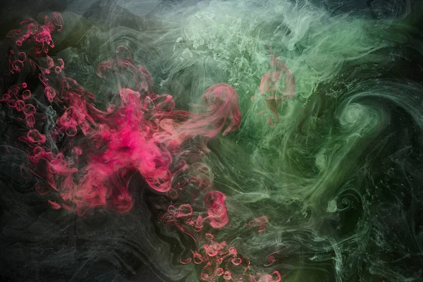 黒インクの背景に緑のピンクの煙 カラフルな霧 抽象的な渦巻くタッチ海 アクリル絵具水中の顔料 — ストック写真
